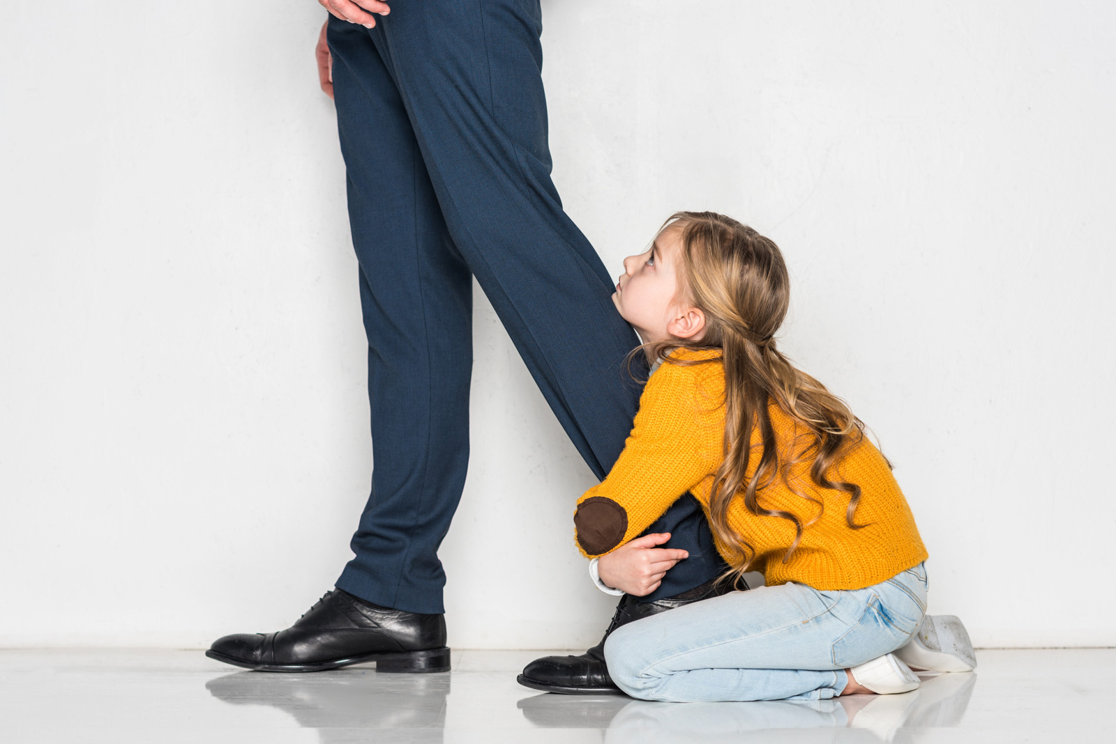 girl holding dad pant leg